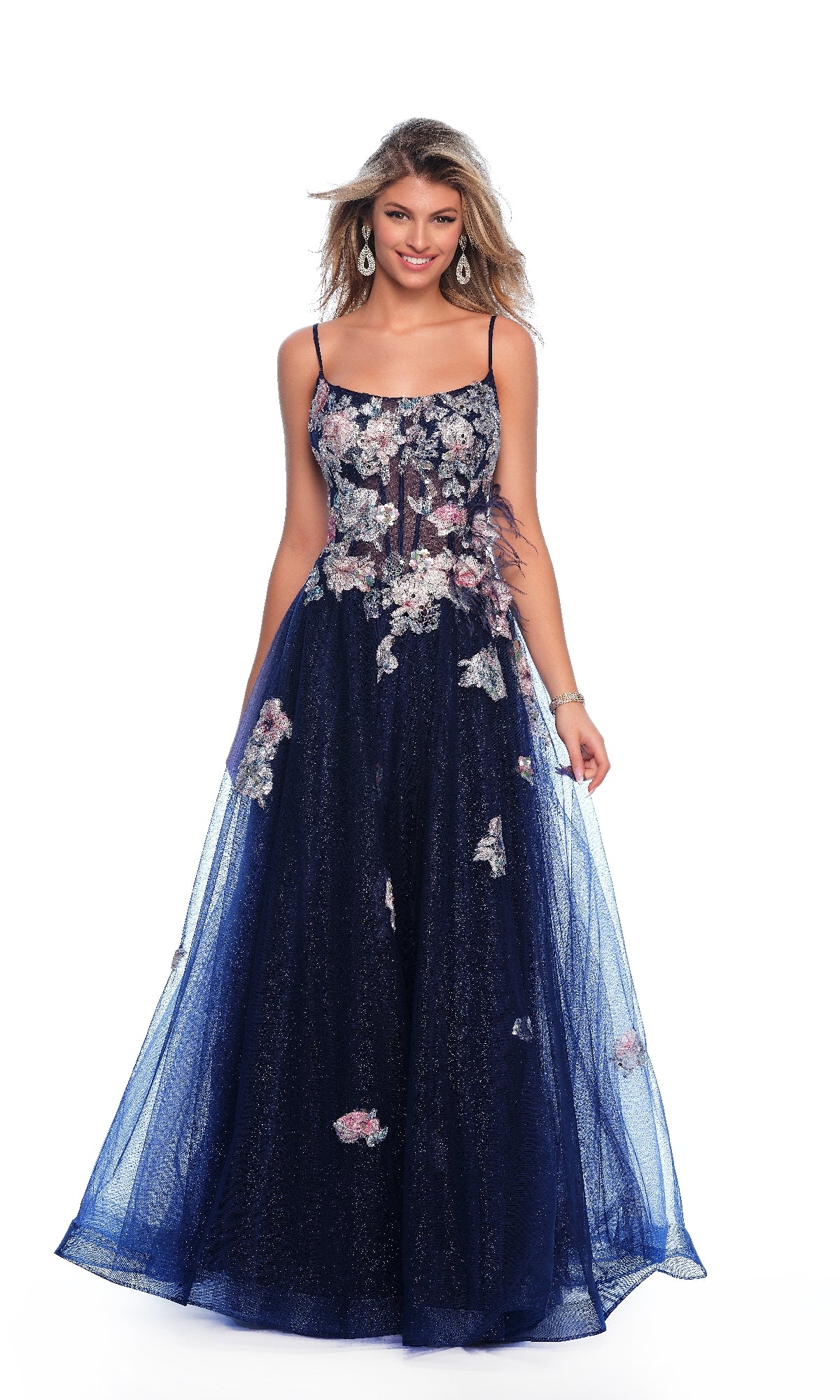 A woman stands against a white background wearing the Dave and Johnny 11870, a long navy blue A-line prom dress with thin straps and 3D floral embroidery.